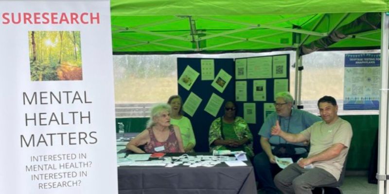 Photo of Suresearch members at our stall with a Sureeasrch banner to the left